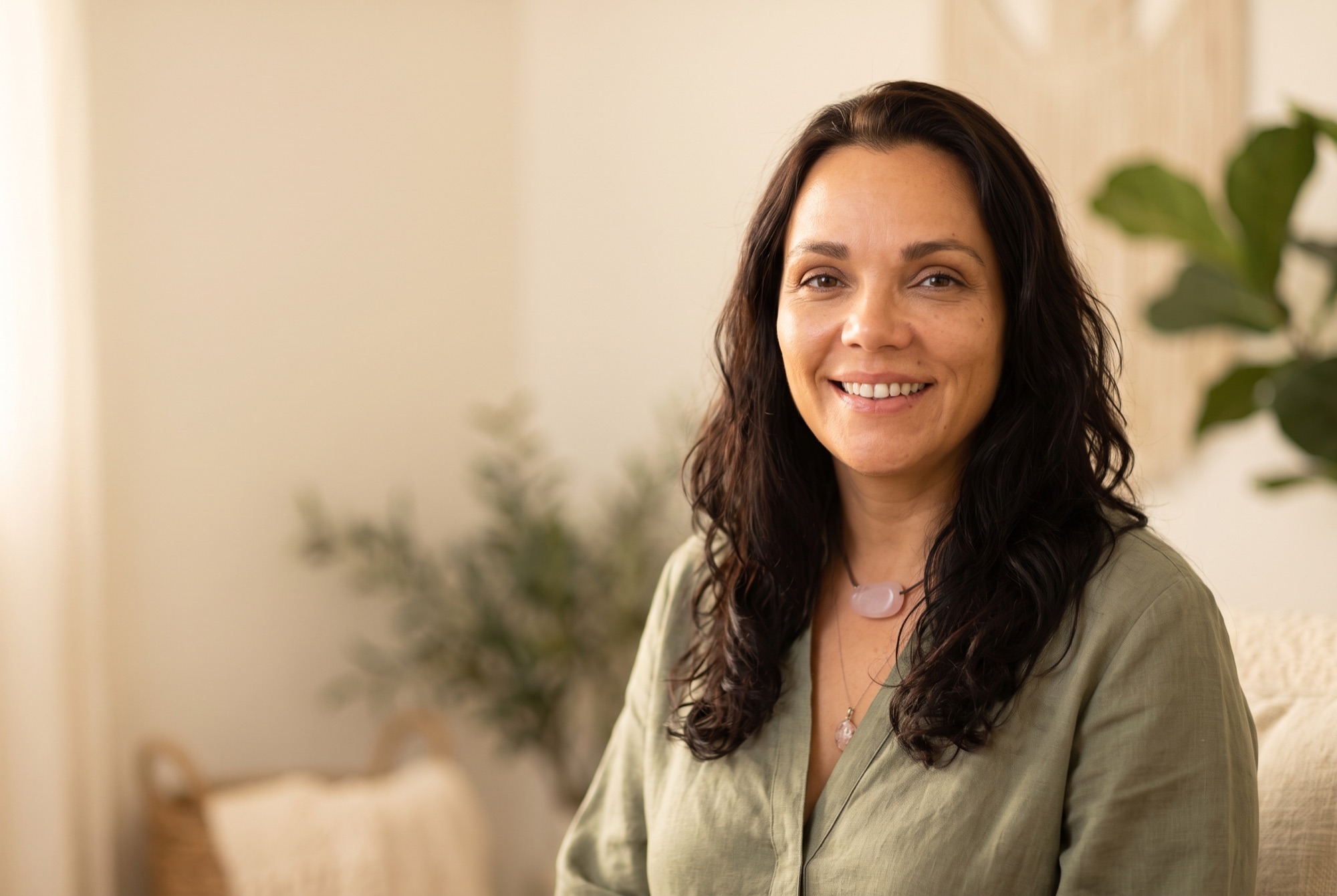 Adriana Lutti sorrindo em seu estúdio de terapia